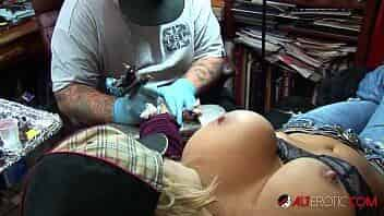 Busty blonde pornstar pulls out her huge tits while getting a tattoo on her wrist video